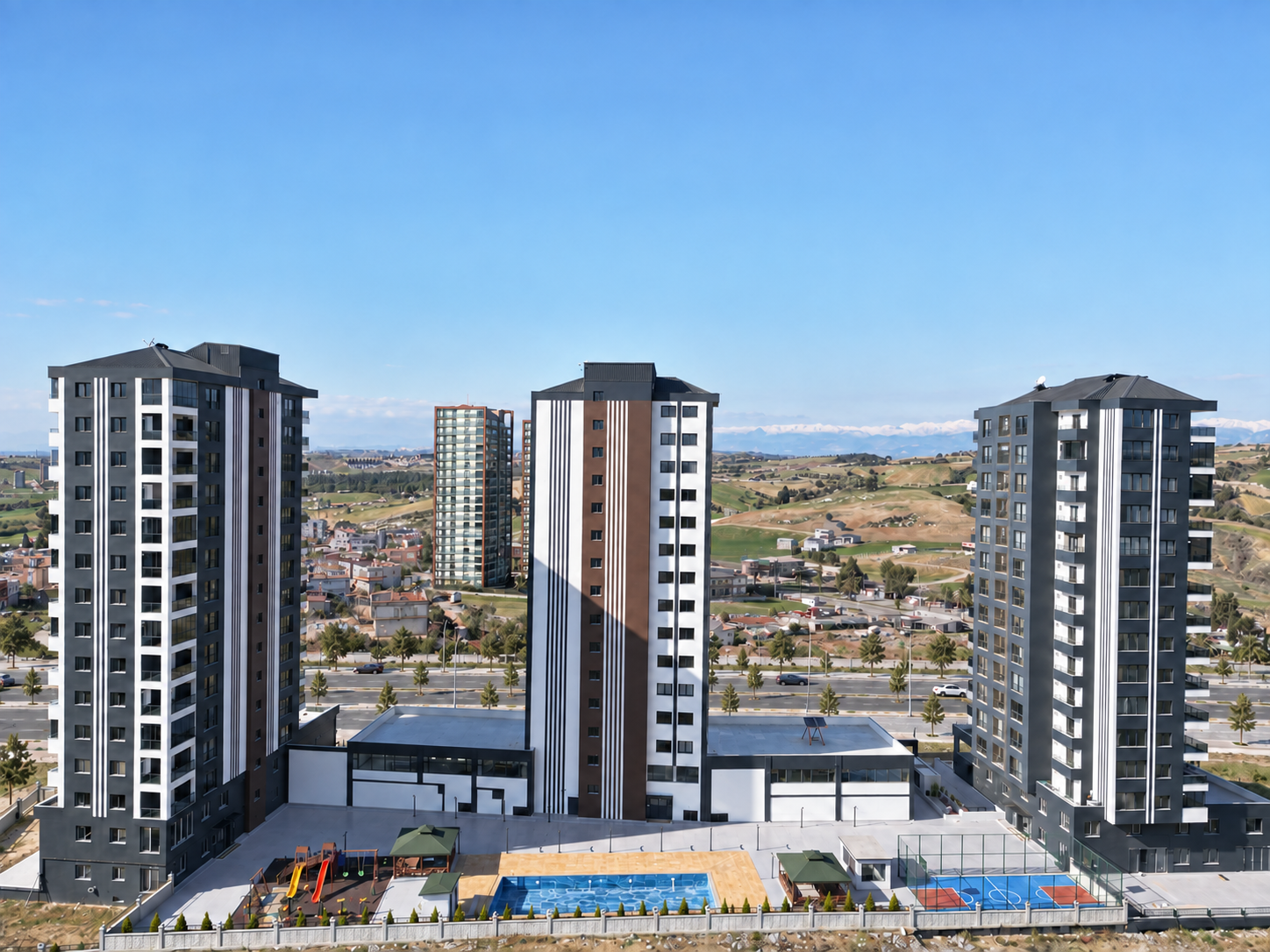 Üç bloğun önünde havuz, çocuk oyun alanı ve basketbol sahasının görüldüğü Tepe Panorama arka cephesi.